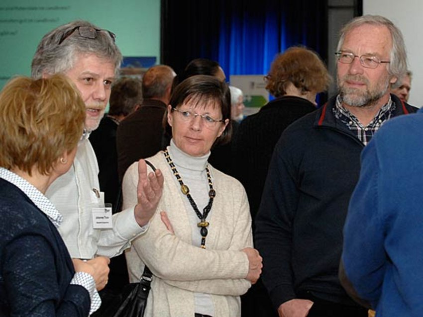 Foto: Einige Teilnehmer der Auftaktveranstaltung unterhalten sich an einer der Themeninseln mit einem Mitarbeiter des Landratsamtes.