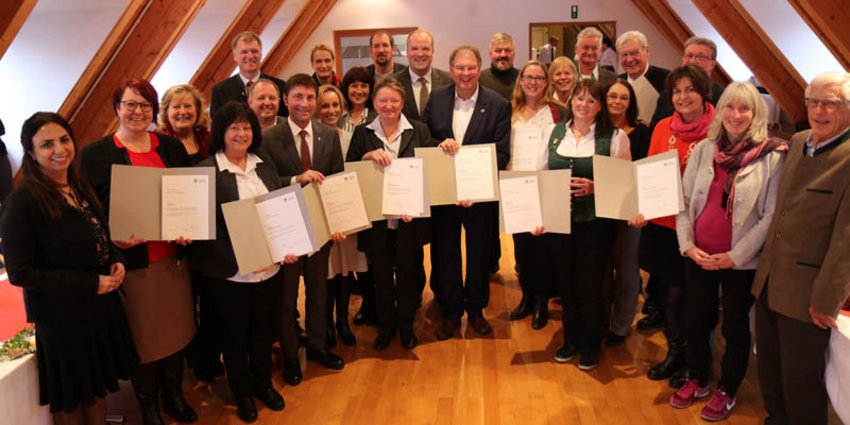 Die Vertreterinnen und Vertreter der neun Pilotgemeinden im Projekt „Demenzfreundliche Kommune“ erhielten von Landrat Christoph Göbel (2. Reihe, Mitte) im Rahmen einer Feierstunde im Festsaal des Landratsamts eine Ehrenurkunde für ihr umfangreiches Engagement zur Verbesserung der örtlichen Versorgungsstruktur für Demenzkranke und deren Angehörige.