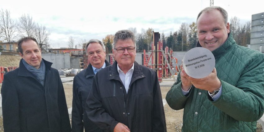 Präsentieren die fertig gefüllte Plombe: (v. r. n. l.) Landrat Christoph Göbel, Putzbrunns Erster Bürgermeister Edwin Klostermeier, Ulrich Bittner (Geschäftsführer Baugesellschaft München-Land) und Michael Amberg (Höss Amberg + Partner Architekten mbB).