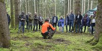 Foto: Ein Mitarbeiter des Bergwaldprojekts stellt das Projekt vor Ort im Wald vor